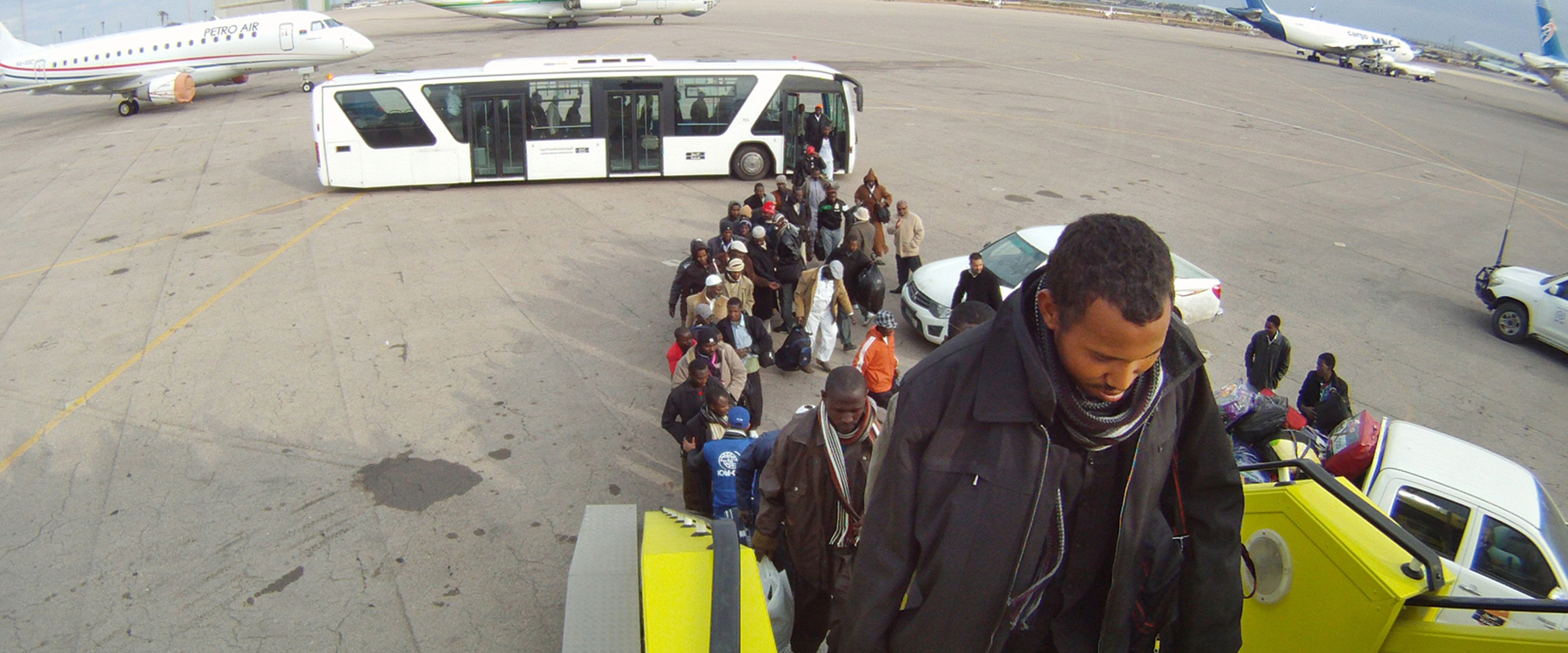 Nigeriaanse migranten stappen in een vliegtuig om terug te keren naar Nigeria. | Foto: IOM, 2012 Nigeriaanse migranten stappen in een vliegtuig om terug te keren naar Nigeria. | Foto: IOM, 2012