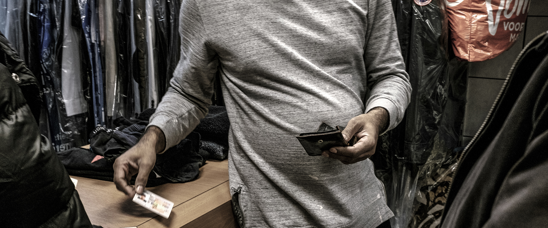 Mogelijk slachtoffer van arbeidsuitbuiting geeft identiteitsbewijs aan de inspecteurs van het ministerie van Sociale Zaken en Werkgelegenheid (SZW), Amsterdam. | Foto: Joris van Gennip | Hollands Hoogte, 2017 Mogelijk slachtoffer van arbeidsuitbuiting geeft identiteitsbewijs aan de inspecteurs van het ministerie van Sociale Zaken en Werkgelegenheid (SZW), Amsterdam. | Foto: Joris van Gennip | Hollands Hoogte, 2017