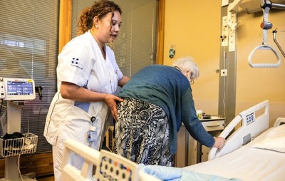 Een Filipijnse verpleegkundige verzorgt een patient op de afdeling Neurologie van het Zuyderland Ziekenhuis in Sittard.