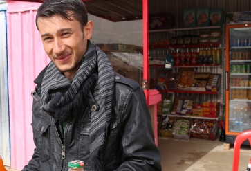 Syrische vluchteling voor zijn winkel in het Gawer Gosik-kamp, Turkije. | Foto: Taryn Fivek | IOM 2015