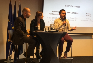 Internationale studenten Rodrigo Velasco (Mexicaans) en Susanna Ambartcumian (Russisch/Armeens) in gesprek met Hans Lemmens, coördinator EMN Nederland