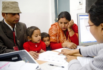 Immigratiemedewerker begeleidt een Indiaas gezien. | Foto: IOM, 2013