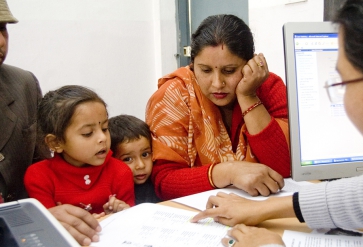 Immigratiemedewerker begeleidt een Indiaas gezien. | Foto: IOM, 2013